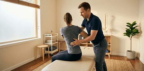 Physiotherapeut unterstützt eine Patientin bei einer Mobilitätsübung